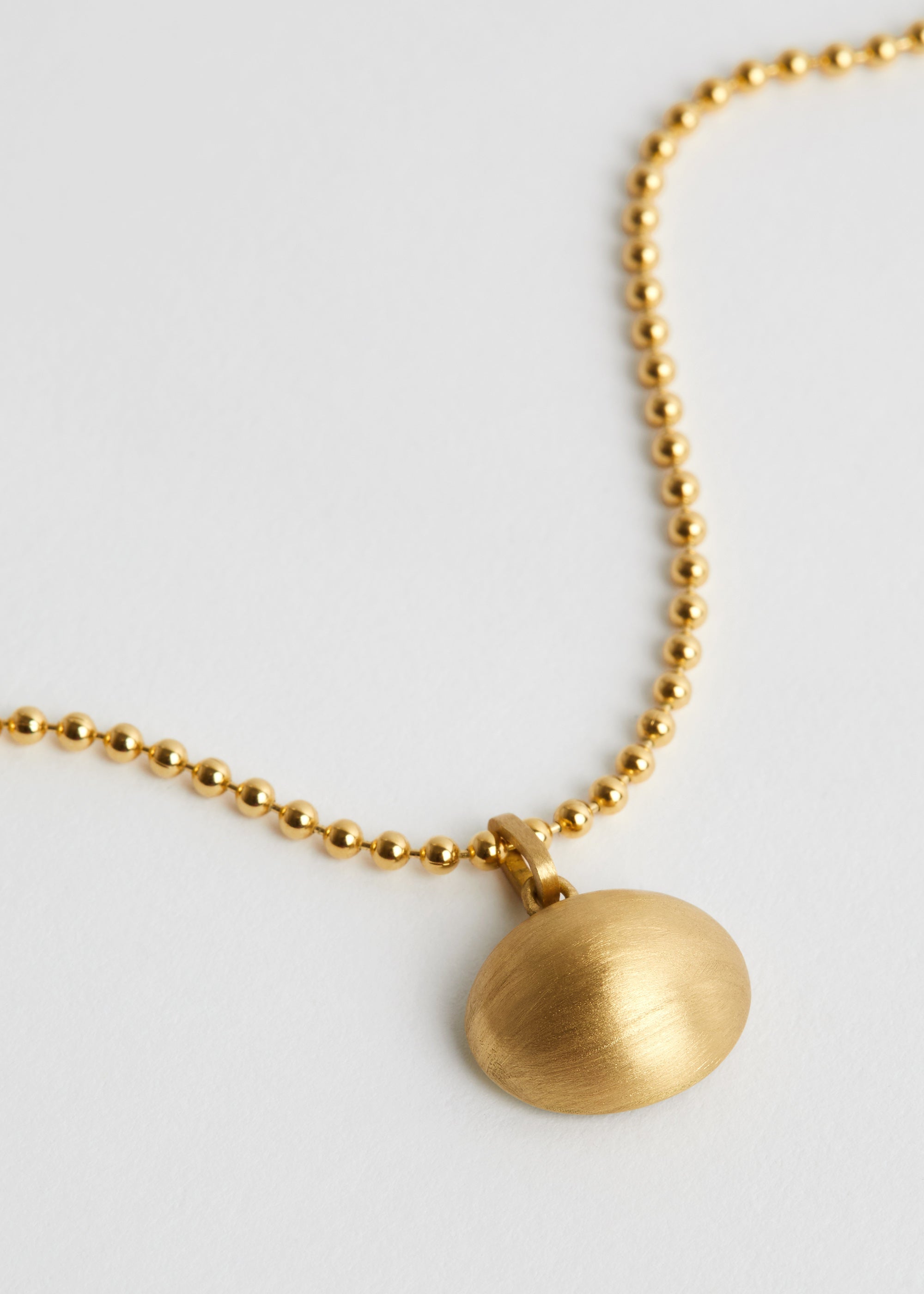 Brushed gold texture detail on AMILA charm by DALINDA